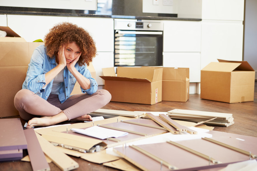 A woman struggling to assemble furniture
